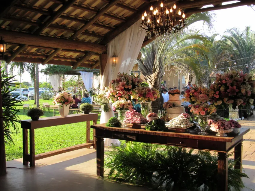 Salão coberto com mesa de apoio e arranjos de flores