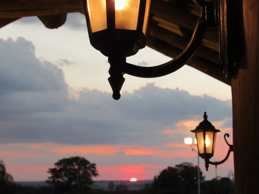 Lampião do jardim recortado contra o pôr do sol
