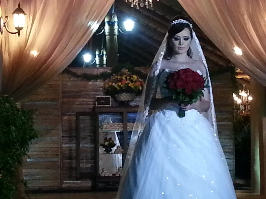 Noiva com buquê no interior do salão de madeira